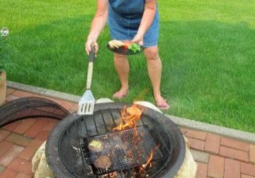 Chris Lyons grilling food over fire