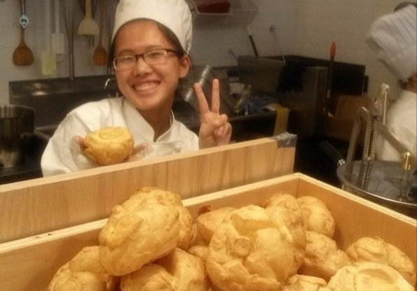 smiling baker with cream puffs